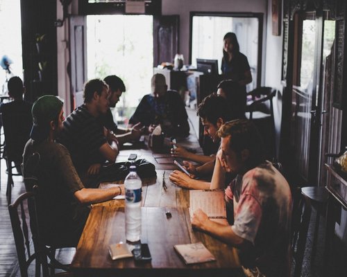 Editorial team members discussing topics in a cafe